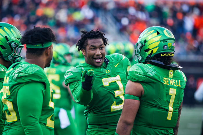 Oregon Ducks defensive lineman Brandon Dorlus on the sideline with Noah Sewell and Taki Taimani.